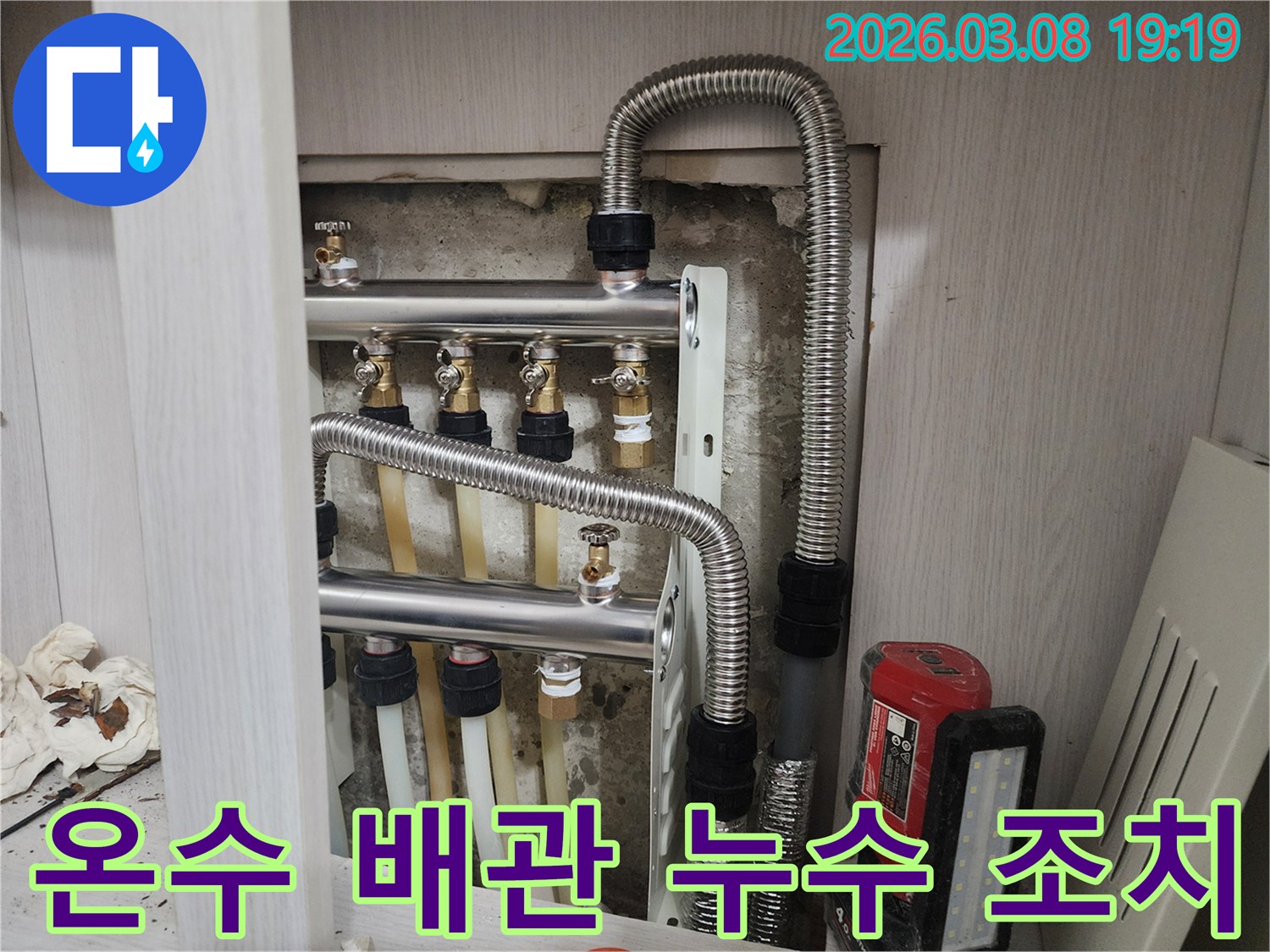 온수-분배기-주변의-배관-연결-상태를-보여주는-사진으로-누수-점검-및-수리-작업이-진행-중입니다