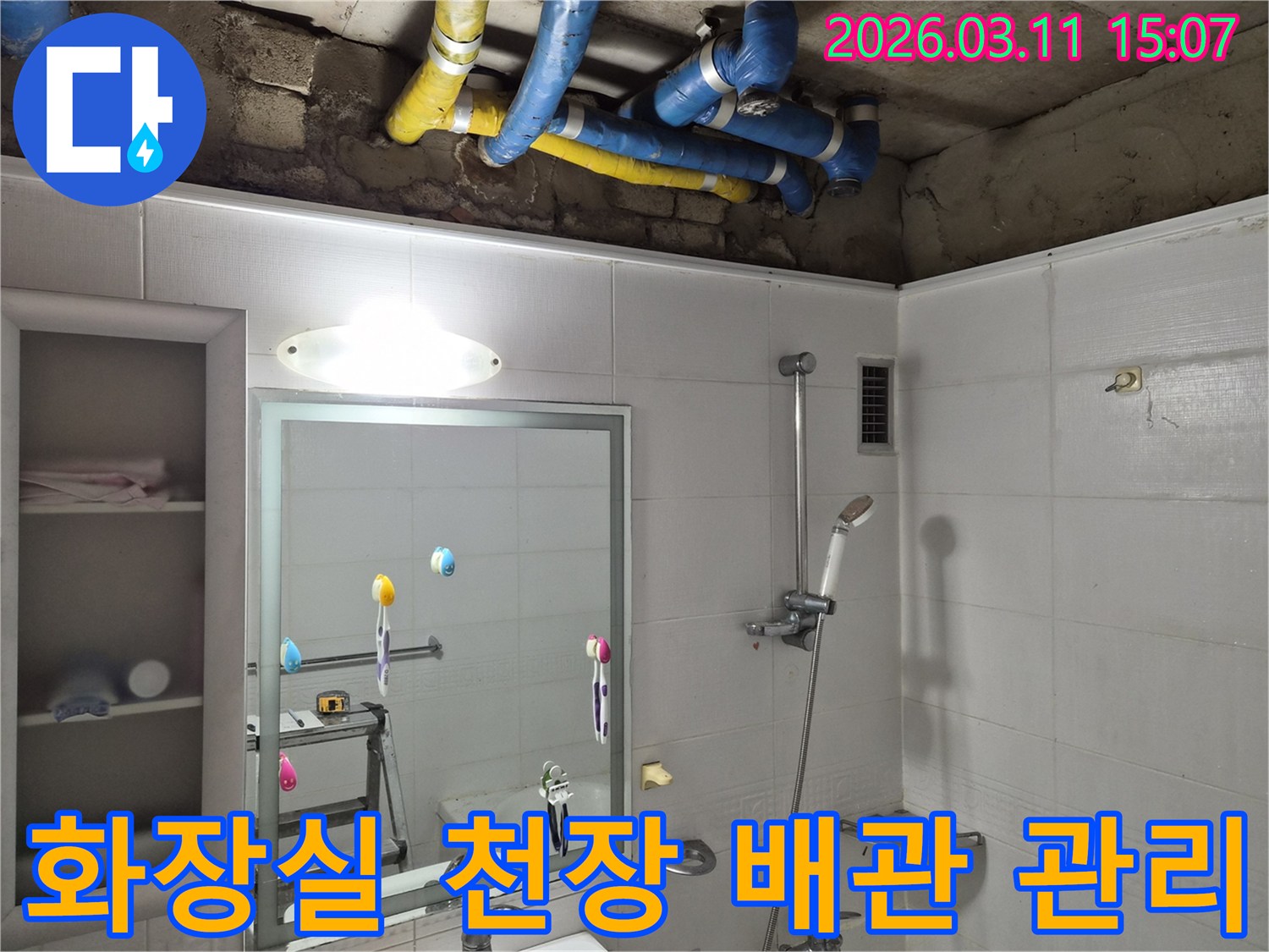 화장실 천장 내부의-파란색과 노란색 배관들이-장기적인 누수 방지를 위해-점검되고 있는 모습