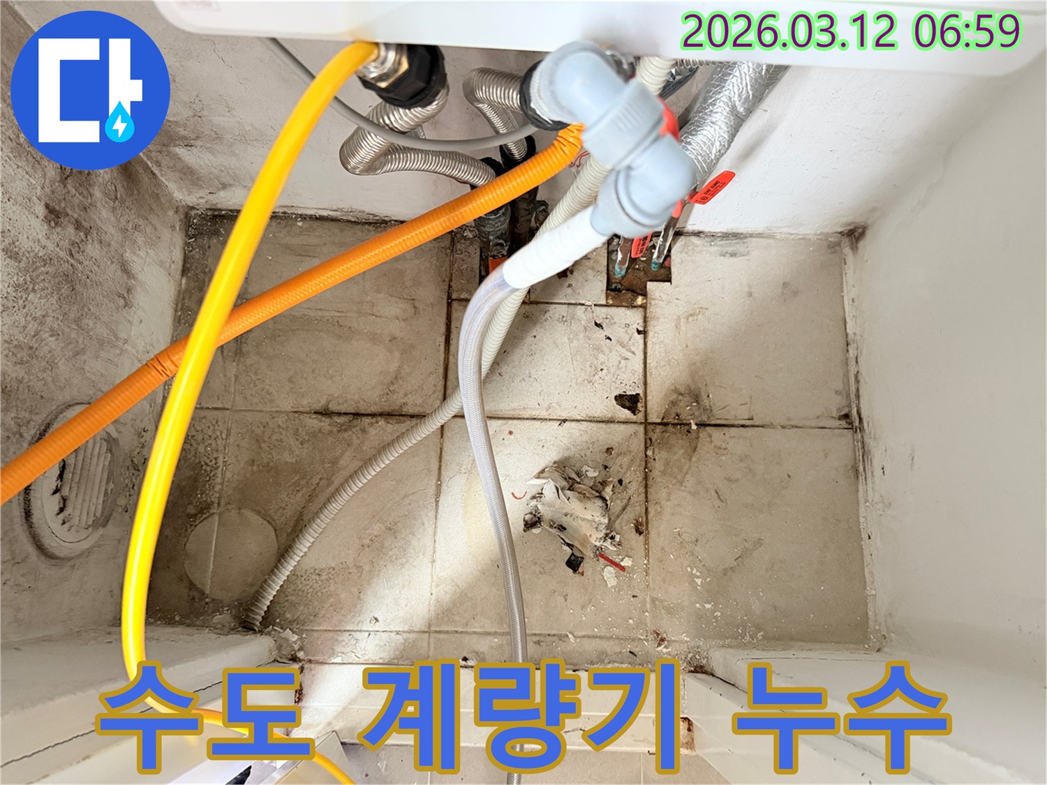 수도 배관들이 얽혀있고-바닥과 벽면에-오염과 물기가 보이는-누수 현장 모습입니다.