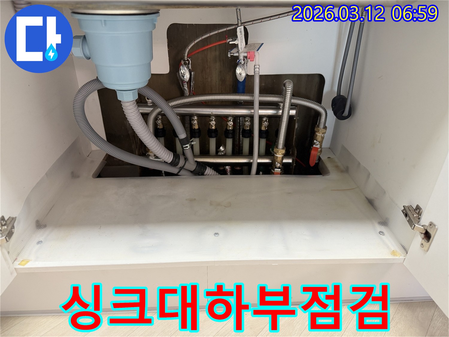 주방-싱크대-하부에서-발생한-물샘-현상을-해결하기-위해-누수-전문가가-배관을-점검하는-모습입니다.