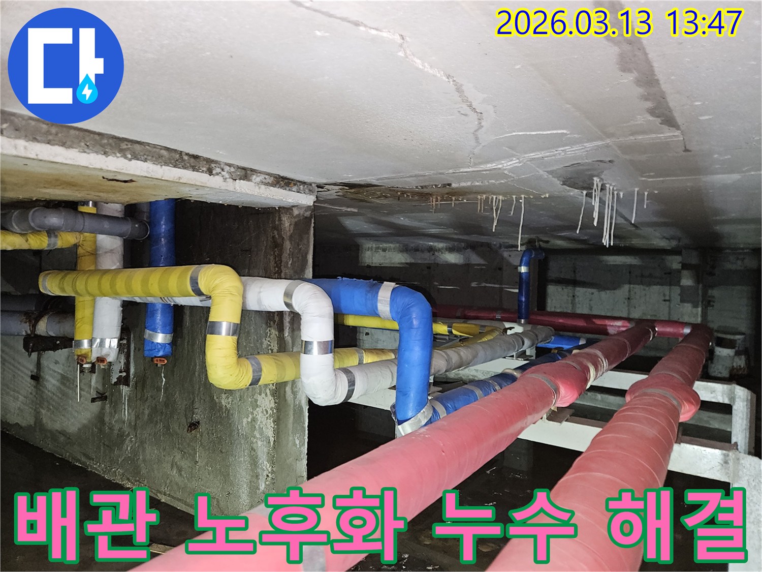 오래된 지하 배관에서-누수가 발생하여-천장과 바닥에-물이 고인 현장을-보여주는 사진으로-배관 노후화가-원인일 가능성을-시사합니다