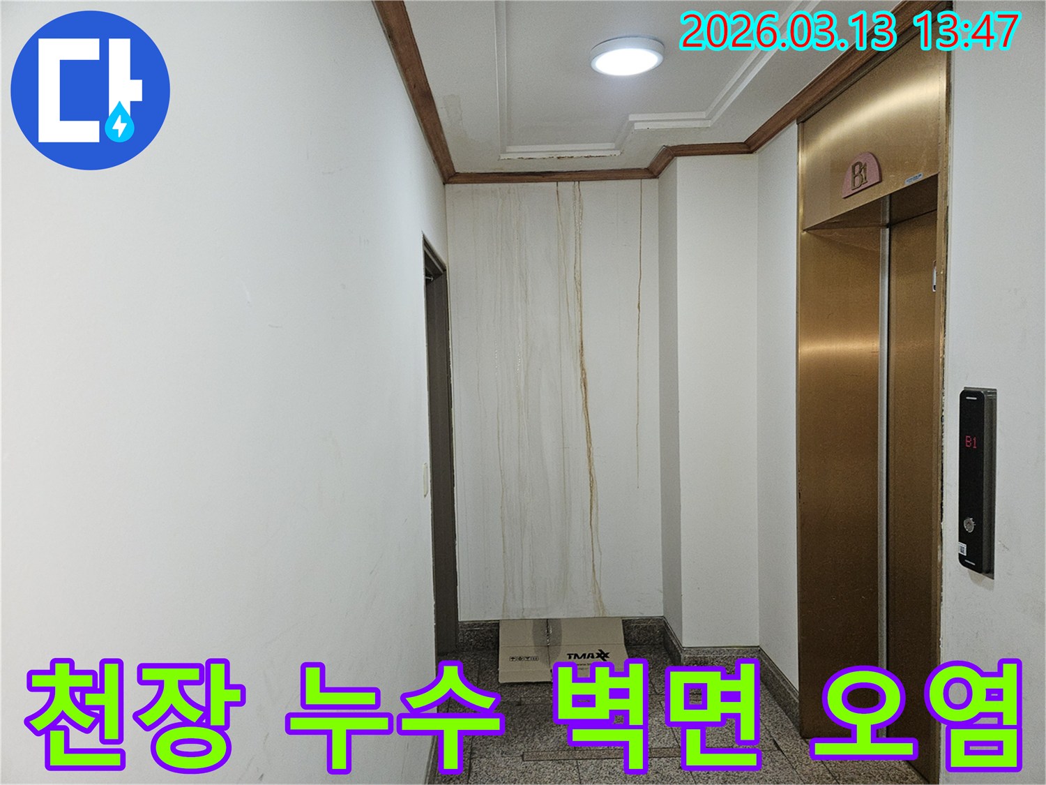 이 사진은 천장에서 시작된 누수로 인해-복도 벽면이 심하게 오염된 상황을 보여줍니다-물이 흘러내린 자국이 선명합니다