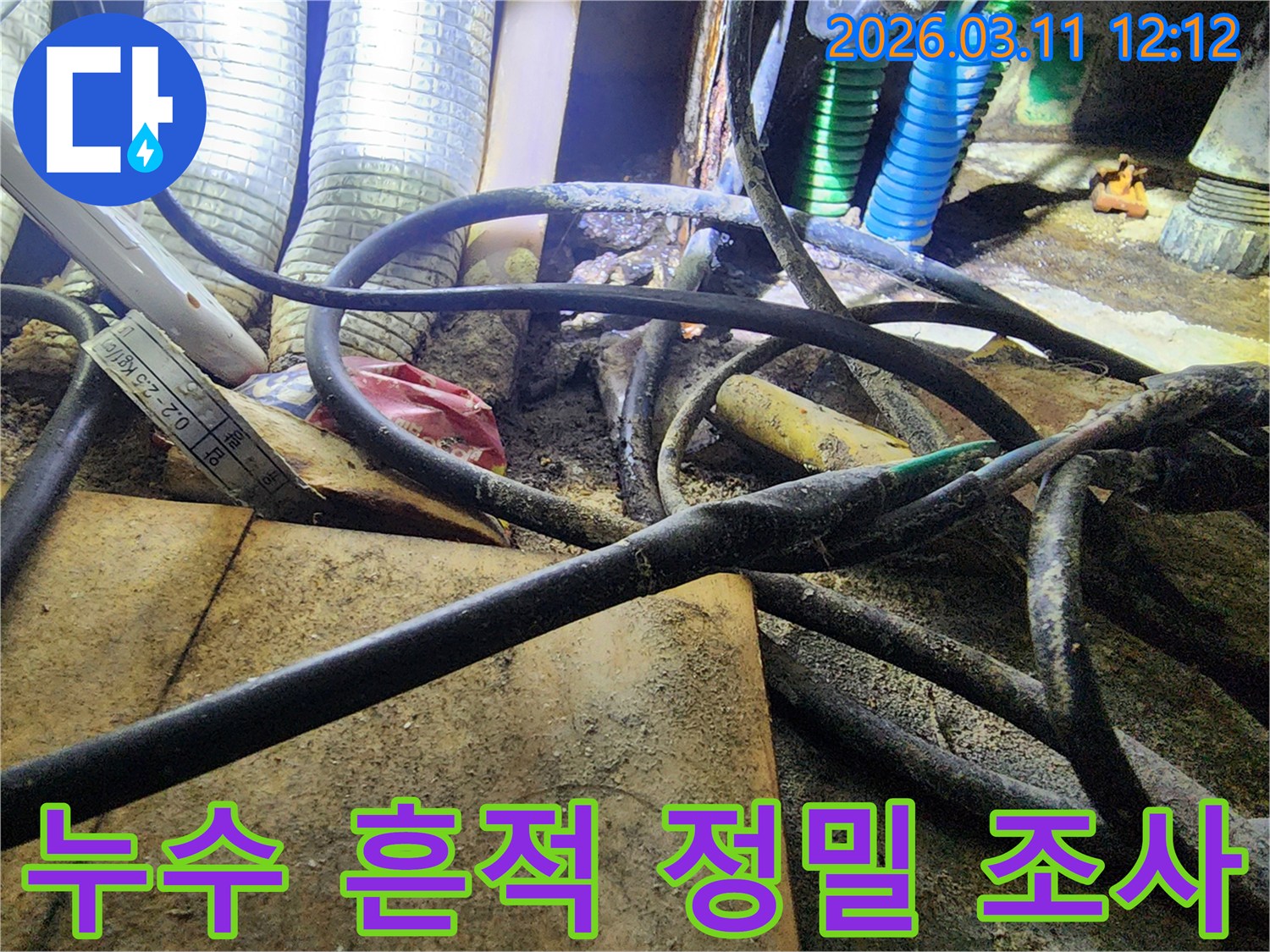 누수-현장에서-배관과-전선-사이의-오염된-부분을-통해-누수-흔적을-정밀하게-조사하는-모습을-담은-사진입니다.