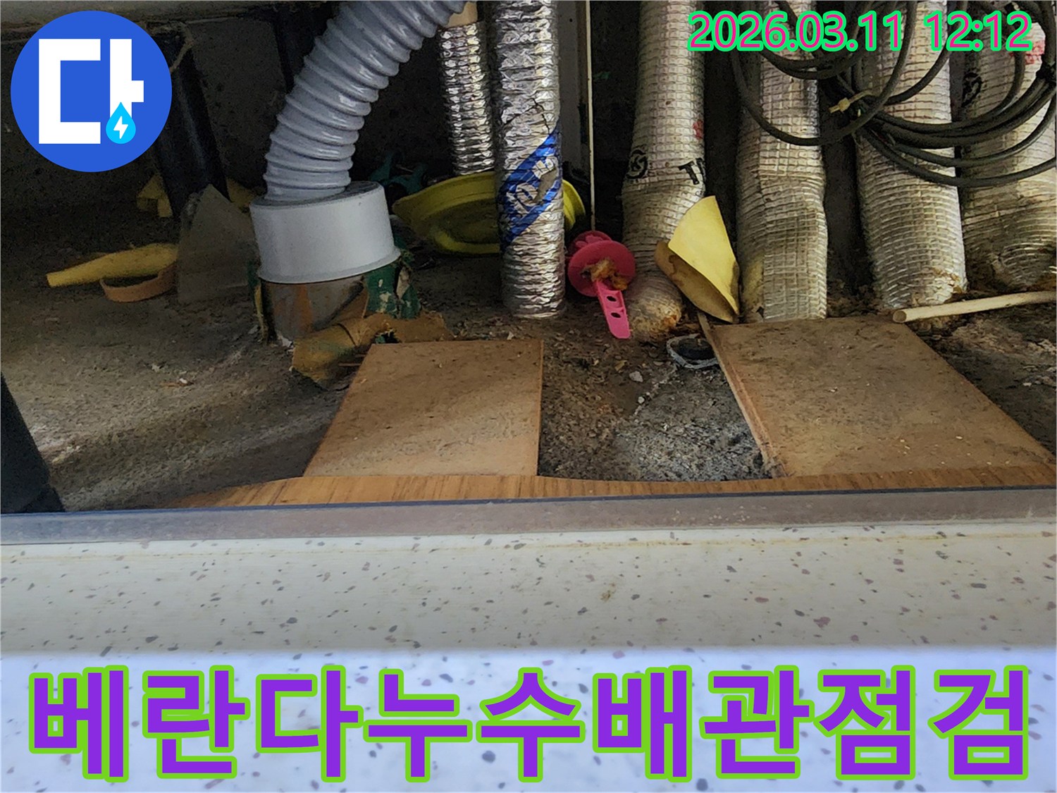 베란다-하부-배관-주변에서-누수-원인을-찾기-위해-전문가가-꼼꼼하게-점검하는-모습을-담은-사진입니다