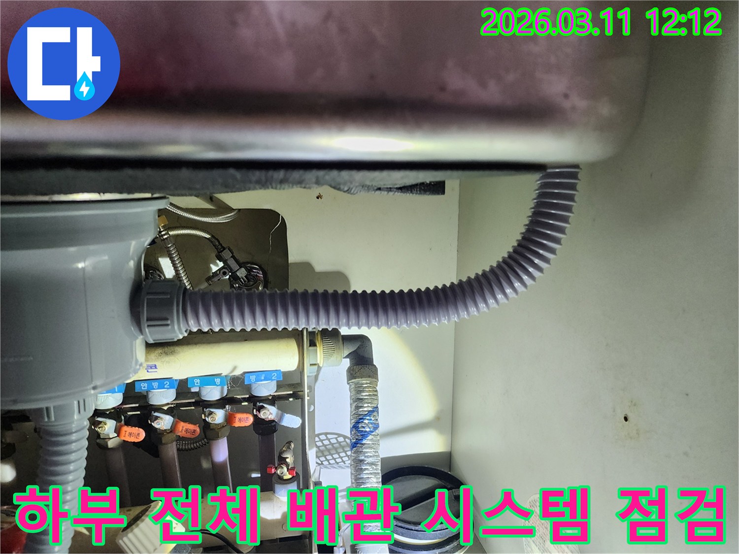 싱크대 하부의-모든 배관과 밸브-연결 부위를-전체적으로 점검하여-잠재적인 누수 위험을-평가하는 모습입니다