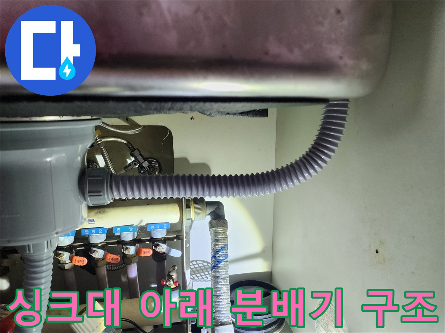 싱크대 하부장 내부의 보일러 분배기와 연결된 유연한 배관들