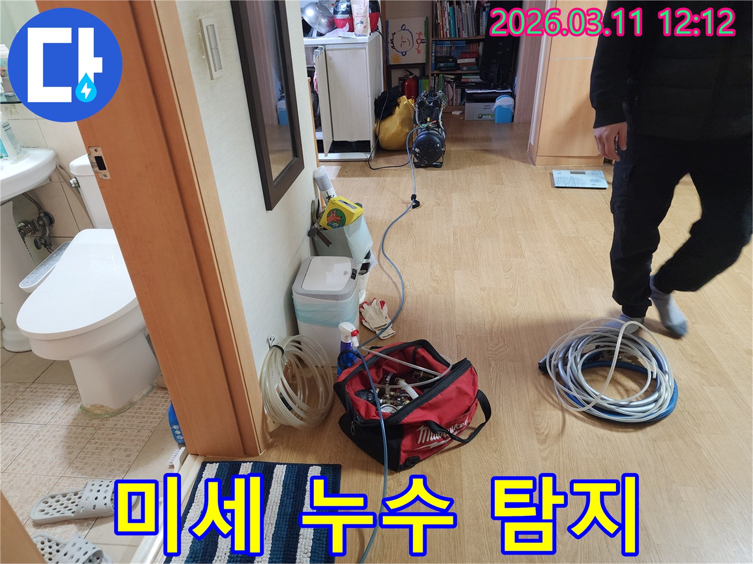 이 사진은-누수 탐지 전문가가-현장에 도착하여-다양한 장비를-준비하는 모습입니다