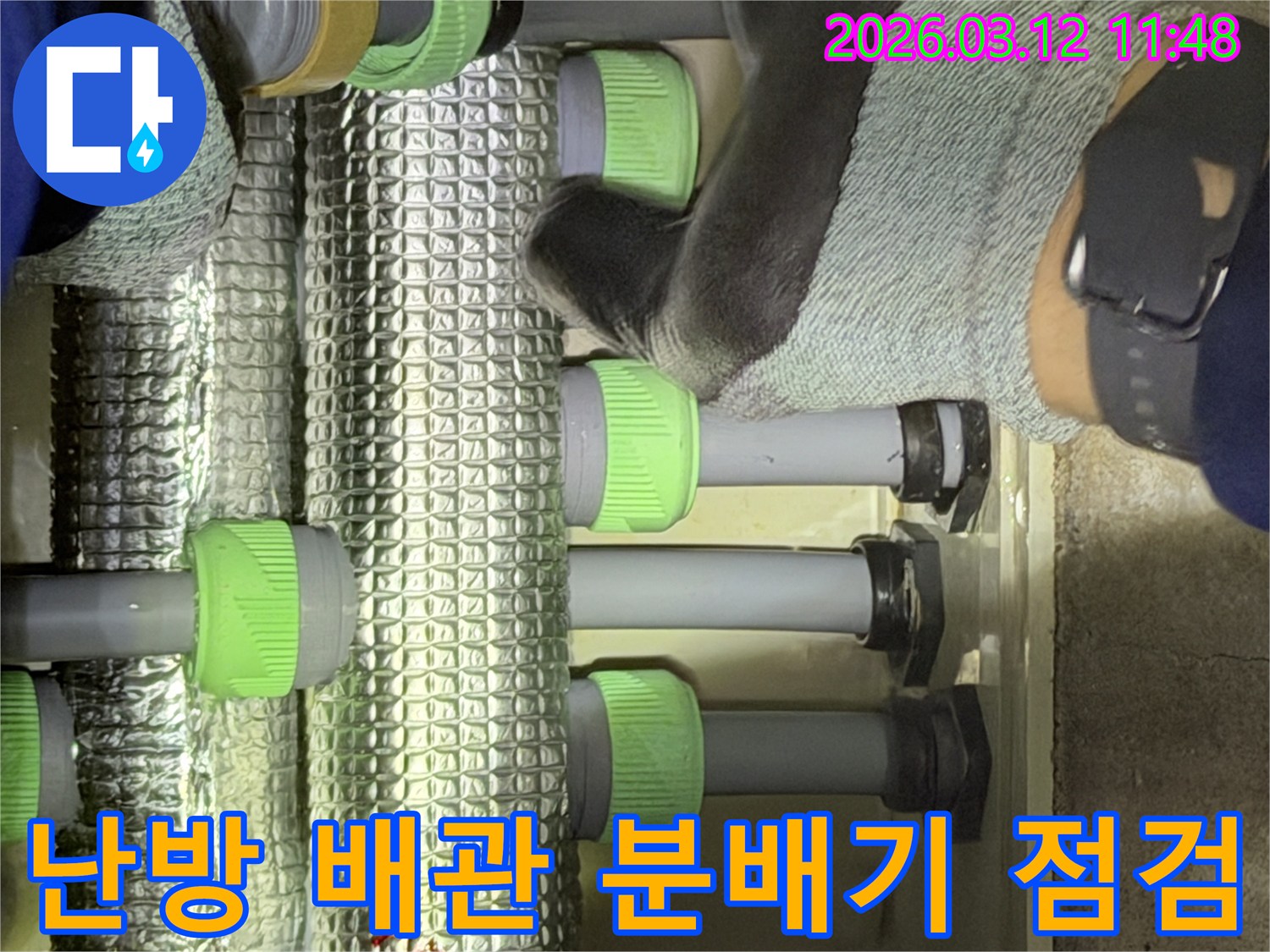 김포-지역의-누수-전문가가-난방-배관-분배기의-연결부를-세밀하게-확인하며-누수-징후를-찾고-있습니다.