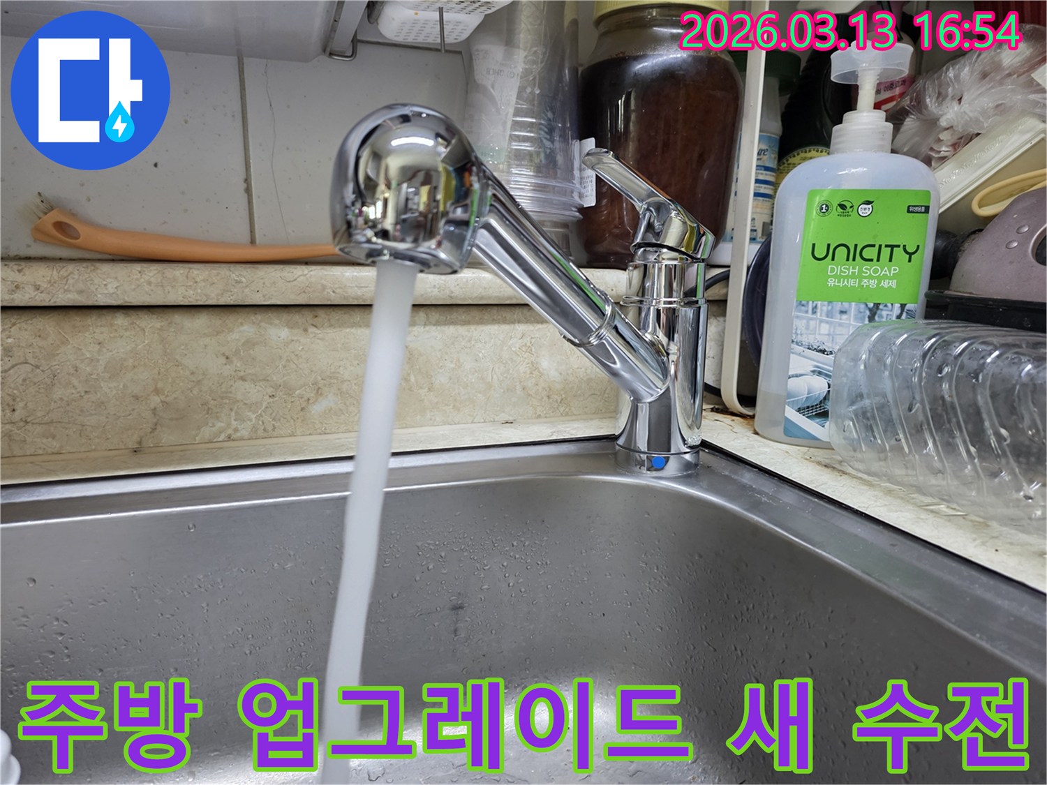 새롭게 교체된 싱크대 수전에서 물이 시원하게 흘러나오는 모습-쾌적하고 위생적인 주방 환경으로 업그레이드되었습니다