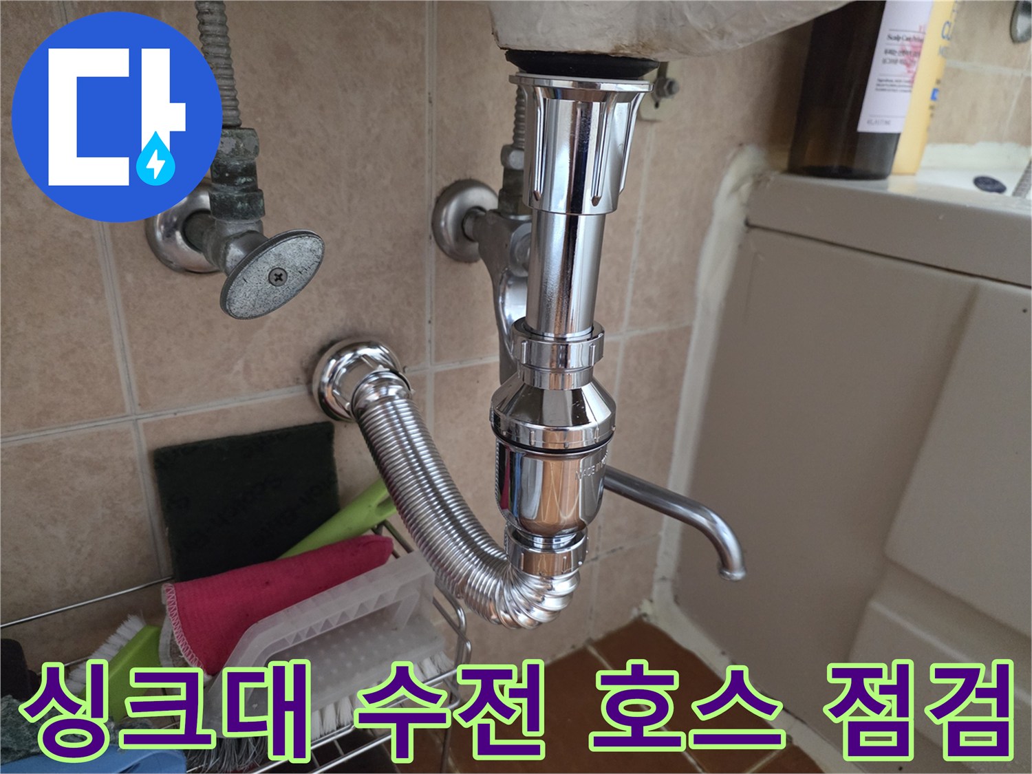 싱크대 하부의 은색 급수 밸브와 자바라 배관 연결 상태를 보여주는 사진입니다.