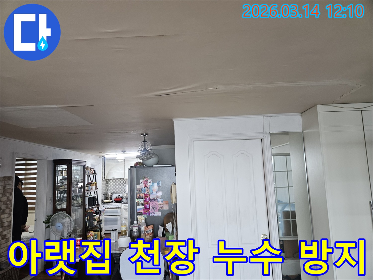 이 이미지는 주거 공간 천장의-누수 피해 현장을-보여줍니다-천장 마감재가 물에 젖어-변색되고-처진 모습은-아랫집으로의 피해 확산을-막기 위한-신속한 조치가-필요함을-시사합니다