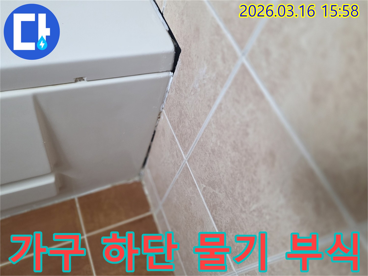 욕실 수납장 하단의 물기 자국과 부식 흔적-누수가 진행 중임을 시사하는 증거