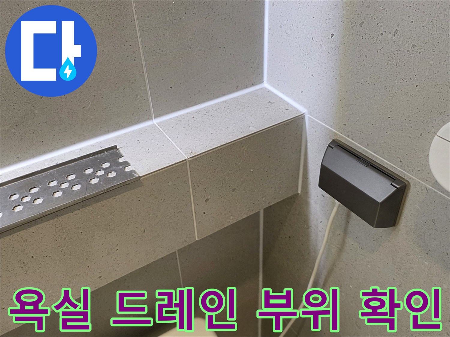 화장실 내부 벽면-배수구와 콘센트 주변 근접 촬영