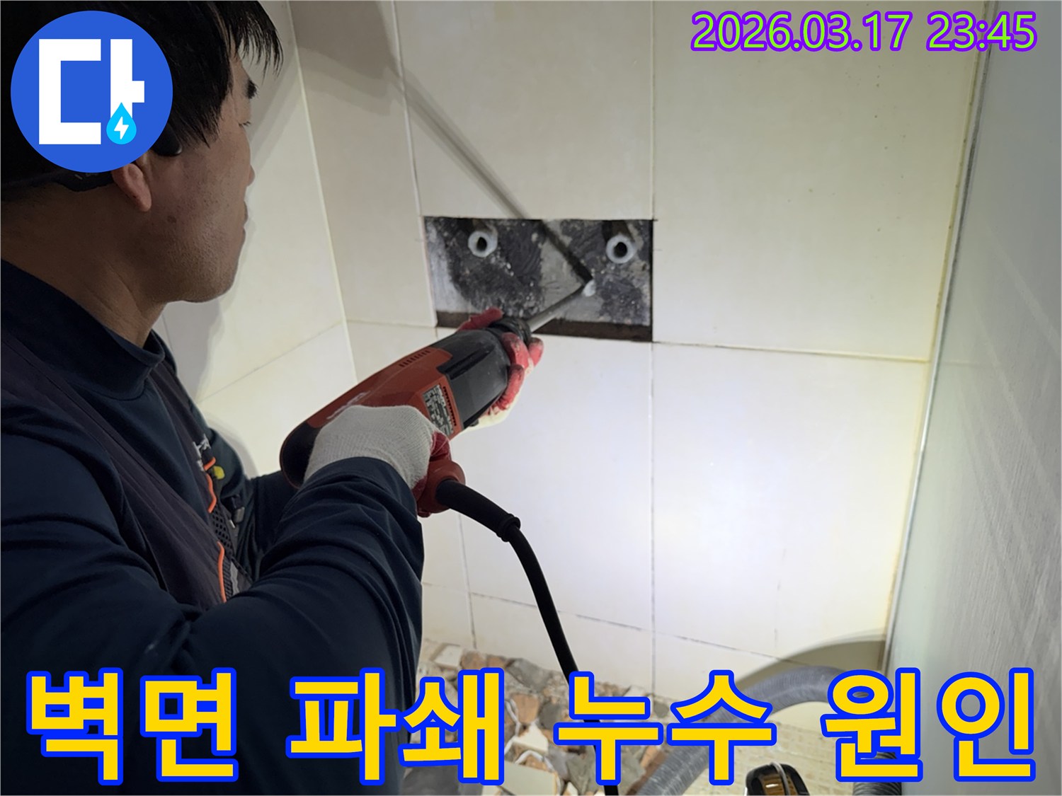 누수 공사 전문가가 욕실 벽면의 타일을 조심스럽게 파쇄하여-누수 원인을 찾기 위한 배관 확인 작업을 진행하는 모습입니다.
