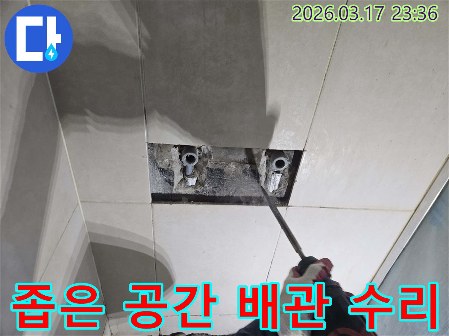 누수 원인을-찾기 위해-벽면 타일을-조심스럽게 파쇄하여-좁은 공간 내-배관 수리 작업을-준비하는-공사 현장입니다