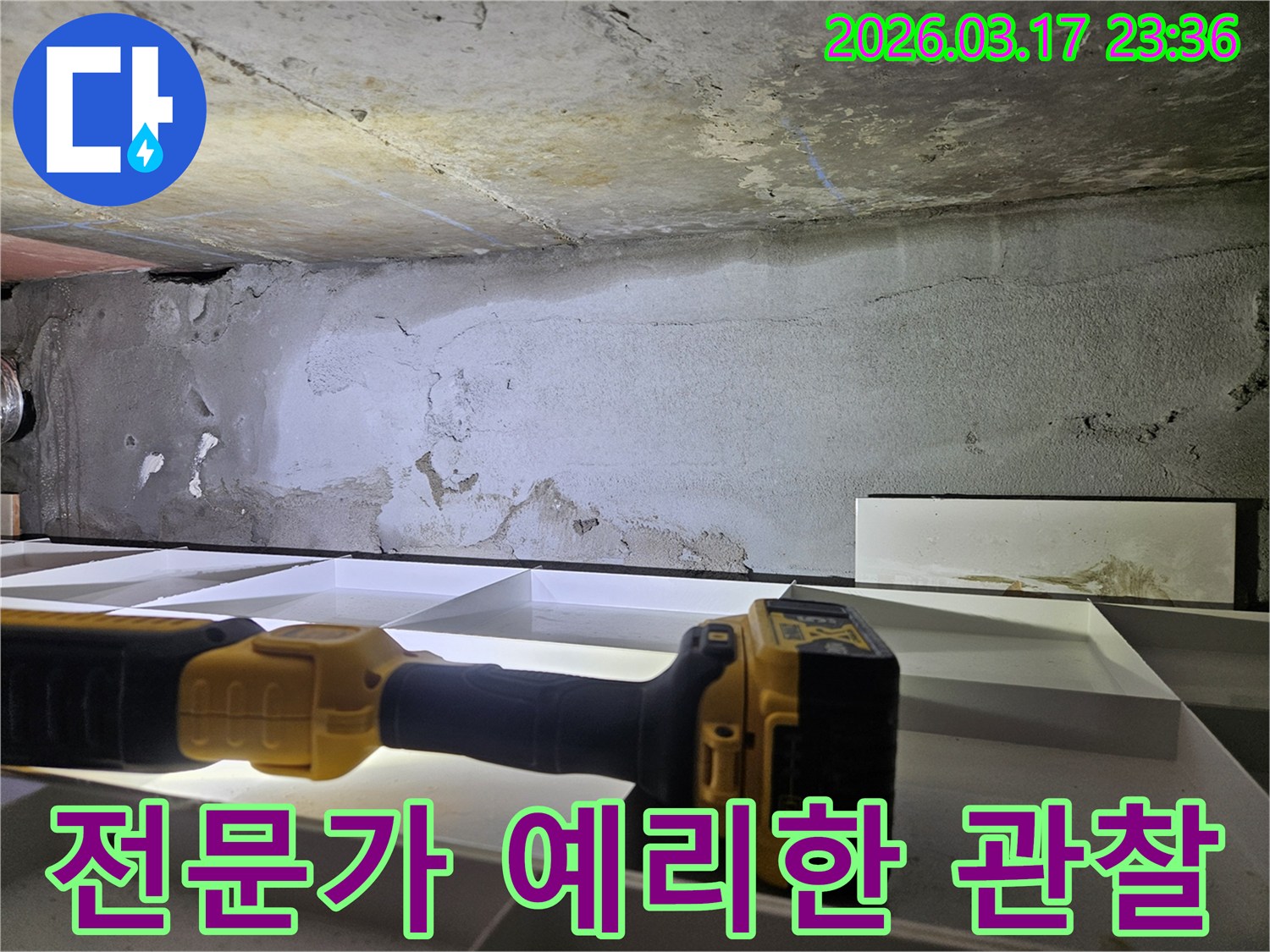 누수 전문 엔지니어가-천장 누수 현장에서-플래시를 이용해-세밀한 육안 검사를 진행하며-누수의 단서를 찾고 있습니다.