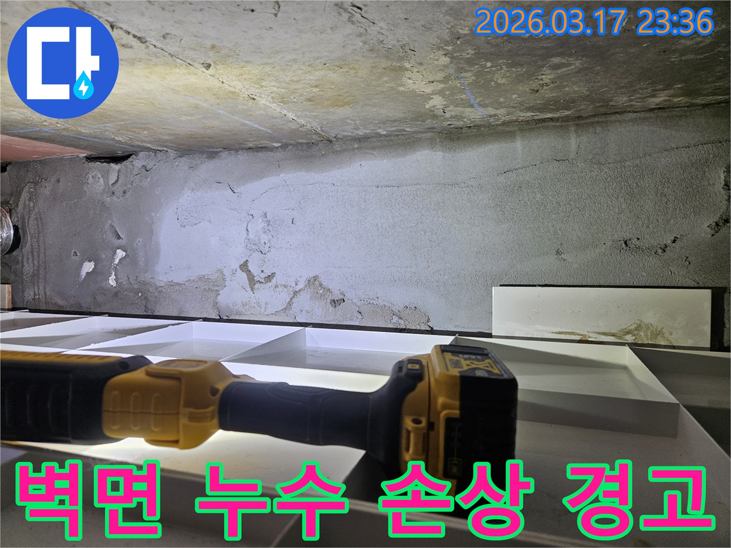 누수 전문 엔지니어가-플래시로 천장 벽면의-페인트 벗겨짐과 변색 등-누수로 인한 손상 부위를-면밀히 확인하고 있습니다.