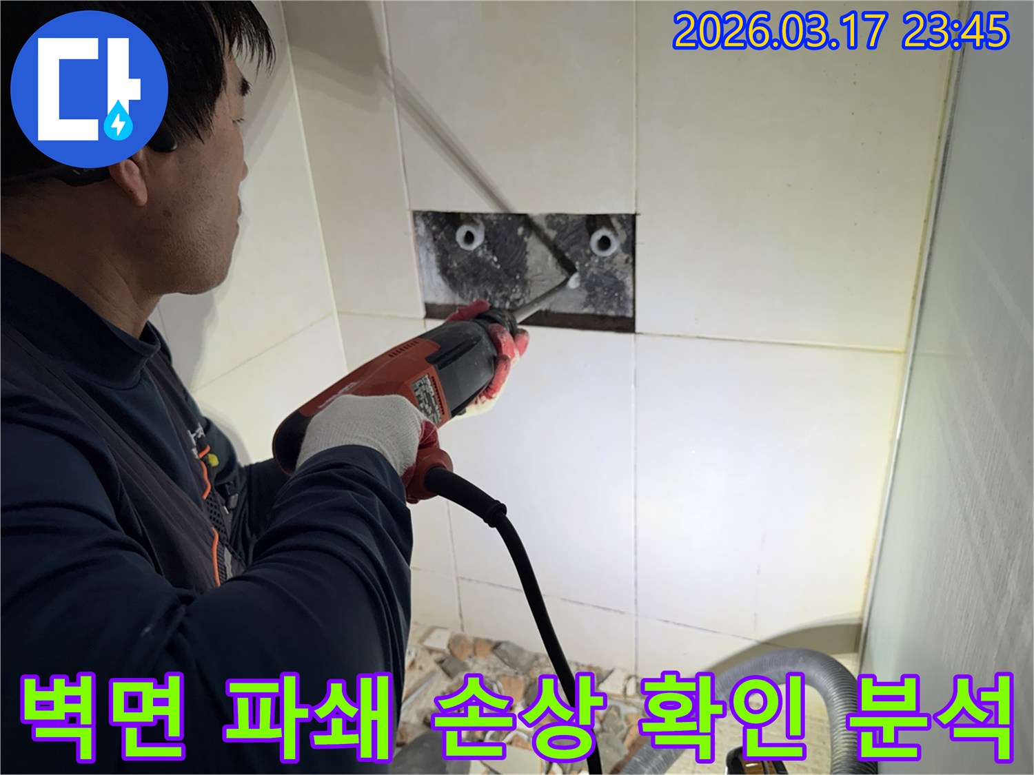 누수 전문가가 벽면 타일을 깨끗하게 파쇄하며-누수 원인인 배관의 손상 부위를 육안으로 확인하고 분석하는 작업을 진행 중입니다.