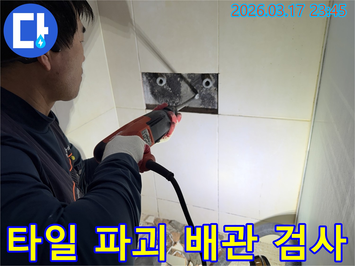 누수 전문가가 욕실 벽면 타일을 파괴하여-숨겨진 배관의 누수 지점을 정밀하게 검사하는 작업 현장입니다.