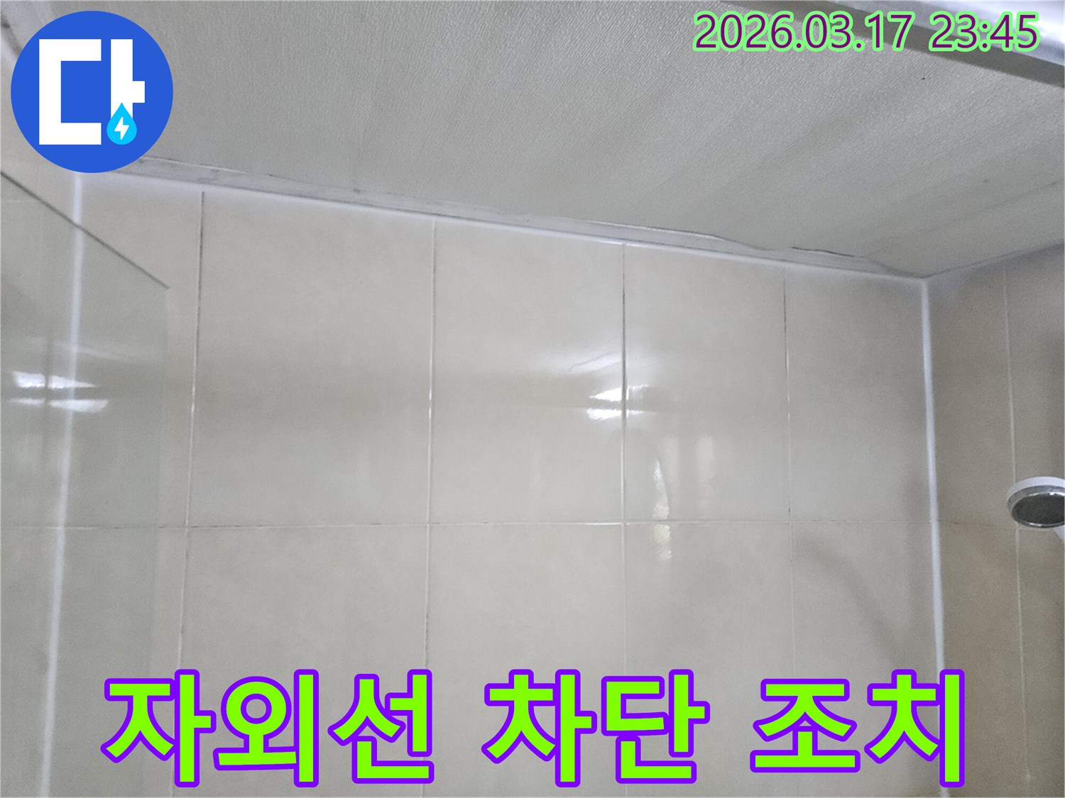 누수-전문가가-타일-벽면과-천장-사이의-이음새에-시공된-방수층을-자외선으로부터-보호하기-위한-조치를-취하는-모습입니다