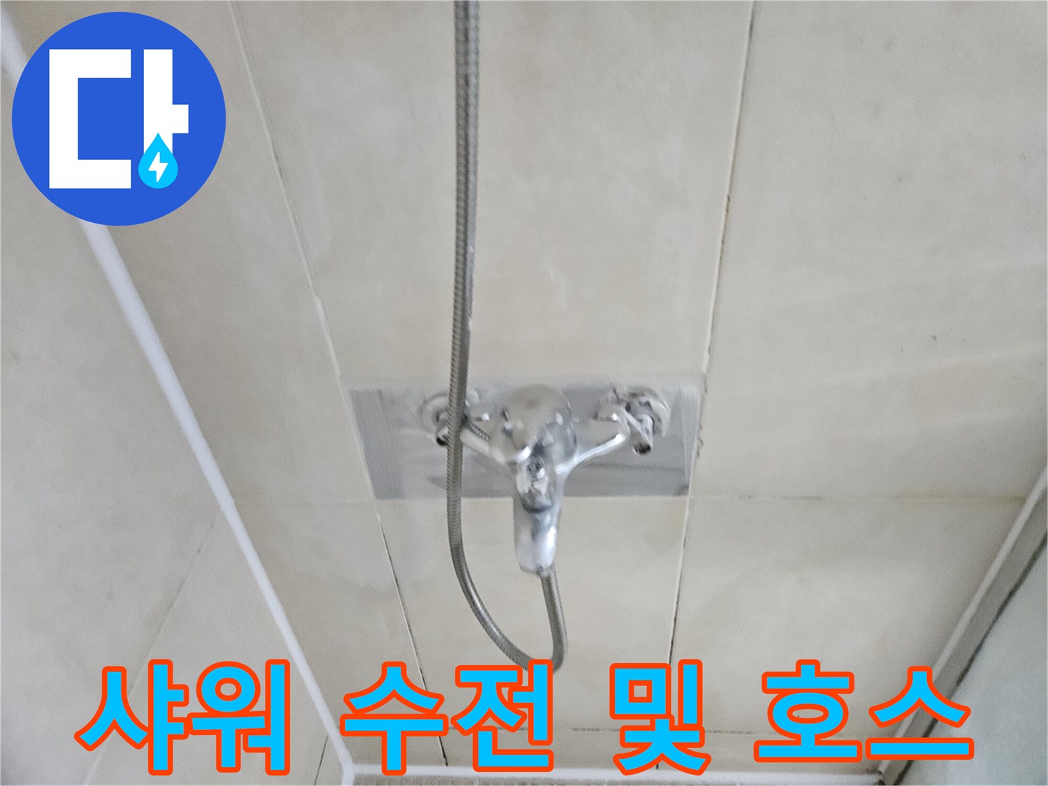 벽면 타일에 설치된 샤워기 수전과 연결 호스 근접샷