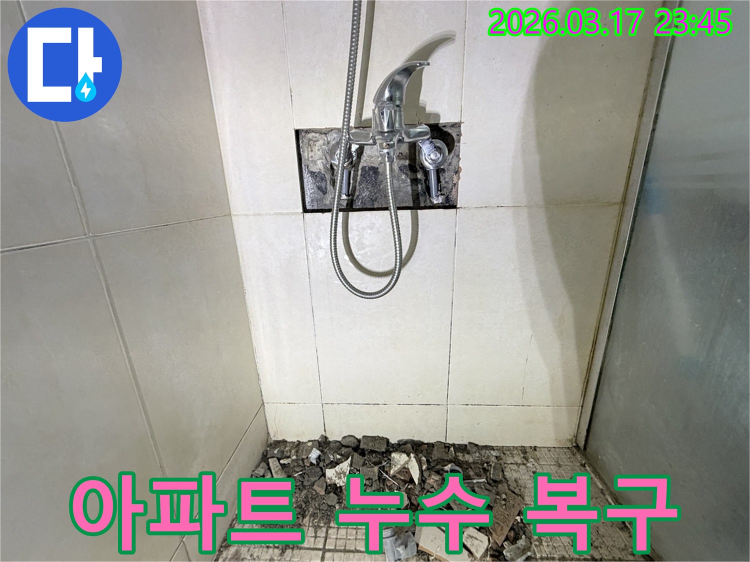 병점동 아파트 화장실에서-누수 피해 복구 및 리모델링을 위해-샤워 수전이 제거되고-바닥 타일이 파손된 채로-공사가 진행 중인 모습입니다.