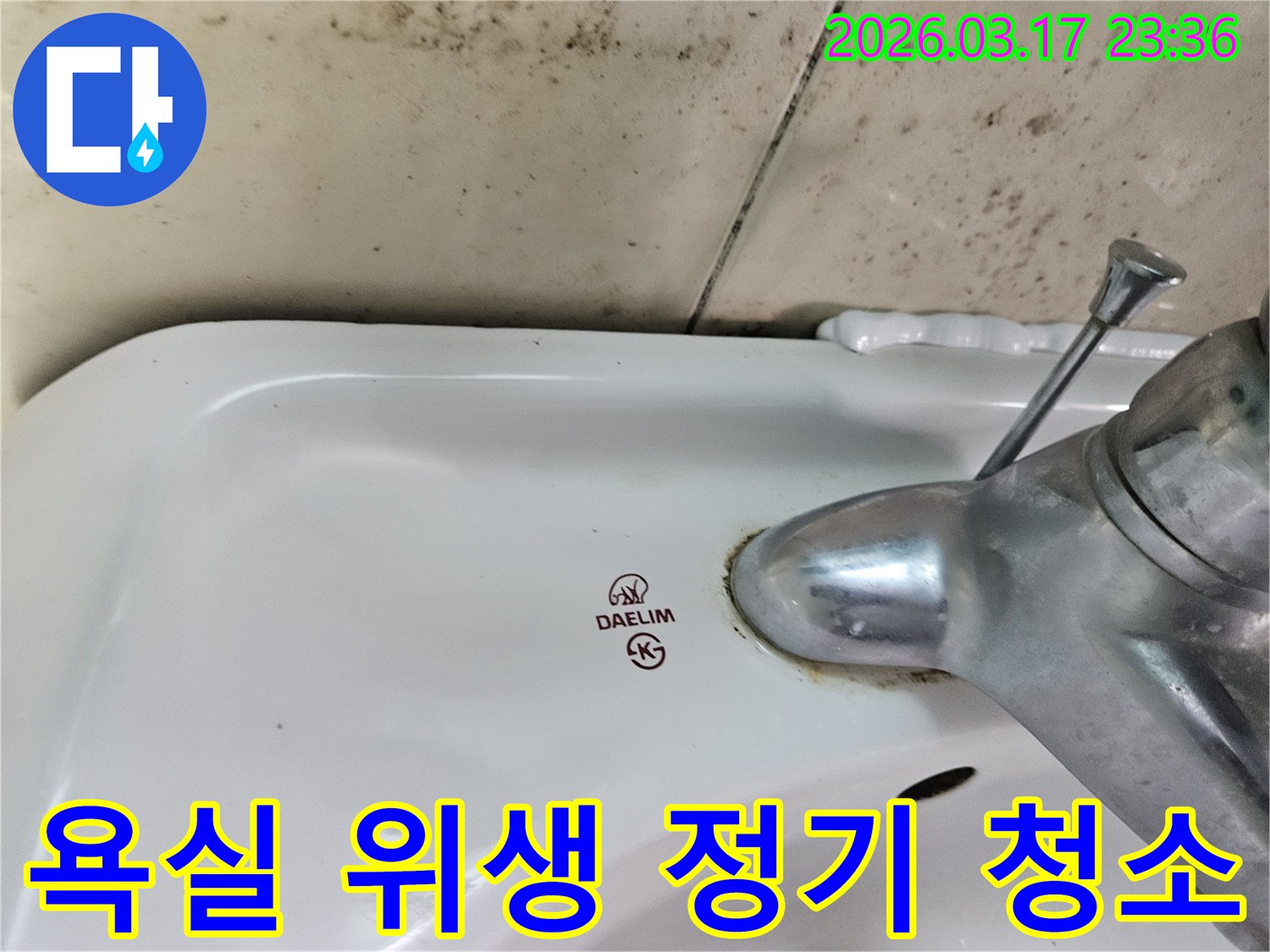 세면대 뒤편 벽의 곰팡이와- 수도꼭지 부식이- 욕실 위생을 위한- 정기적인 청소 및 관리의- 중요성을 보여줍니다