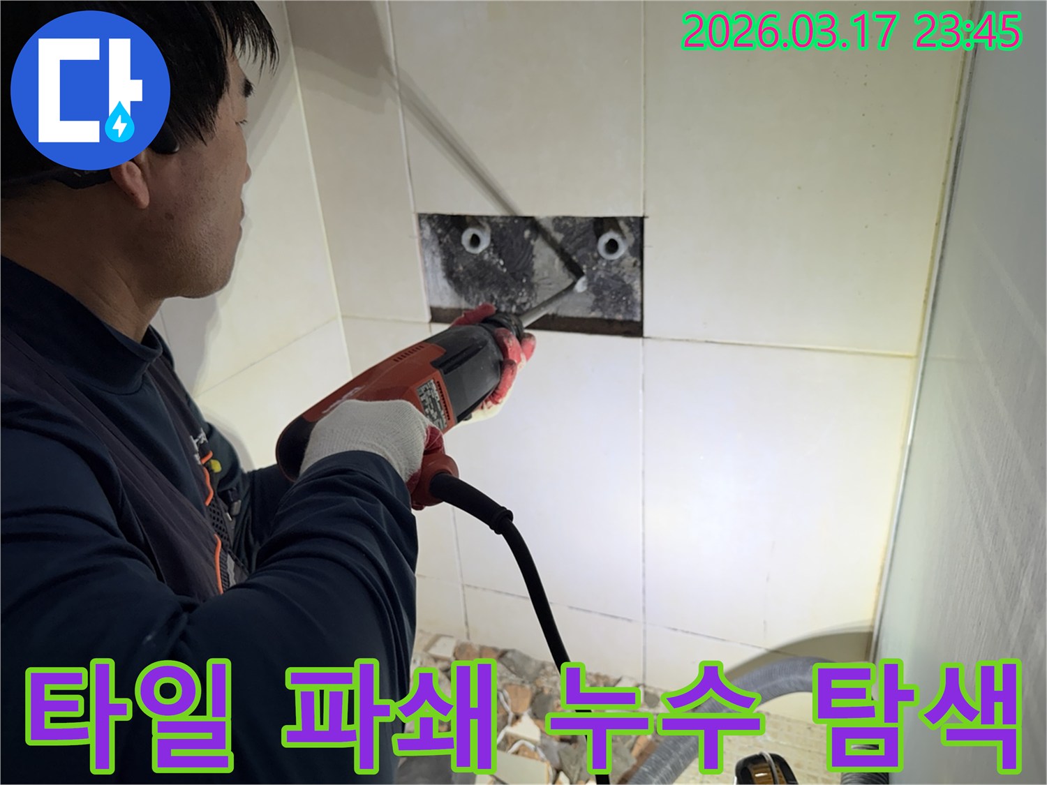 숙련된 기술자가 누수 지점을 찾아내기 위해-벽면 타일을 깨고 내부 배관을 드러내는 작업을 진행하고 있습니다.
