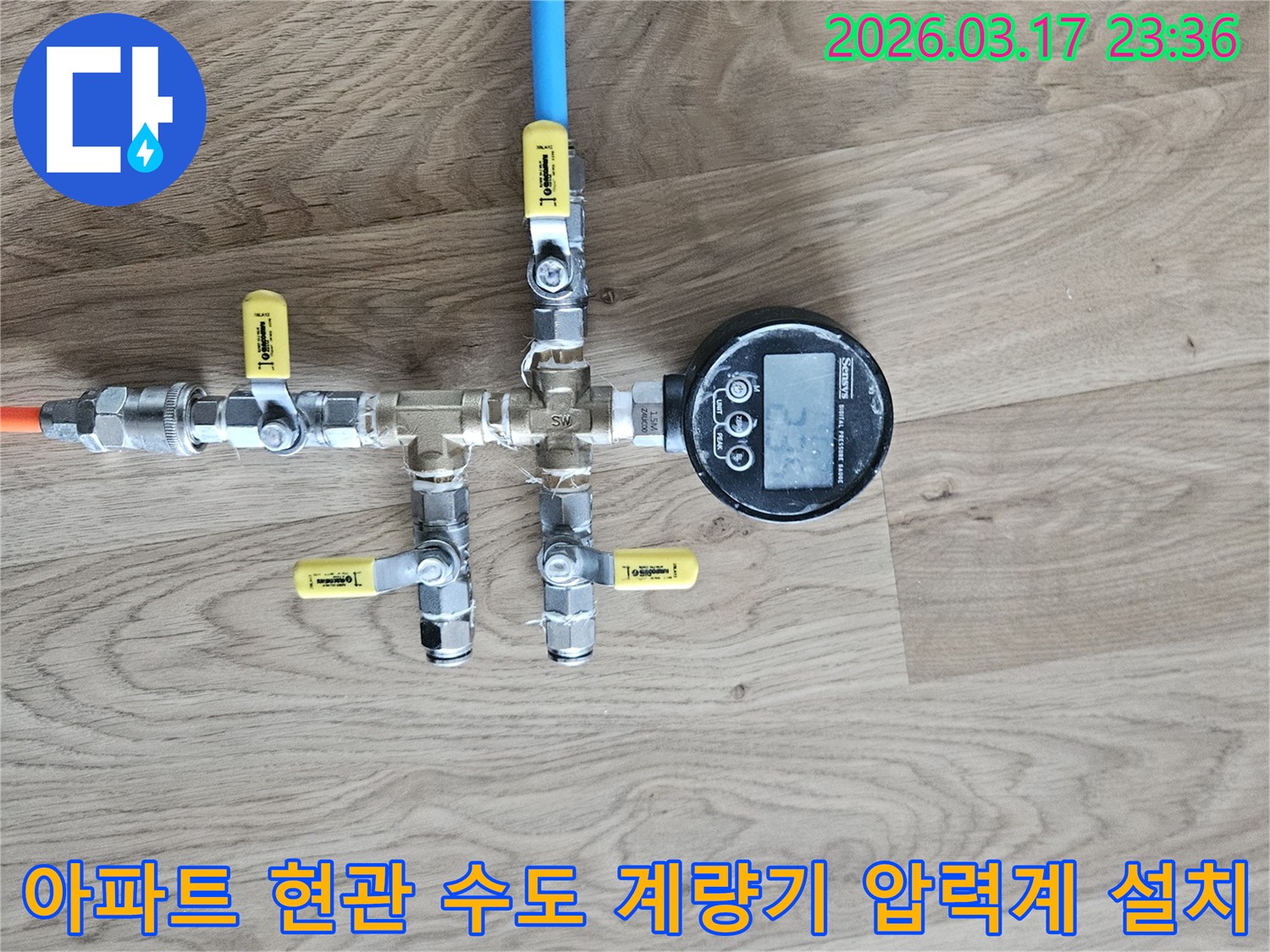 아파트 현관 앞 수도 계량기 배관의 누수 여부를 확인하기 위해-압력계를 설치하고-정확한 수치를 측정하는 과정입니다.
