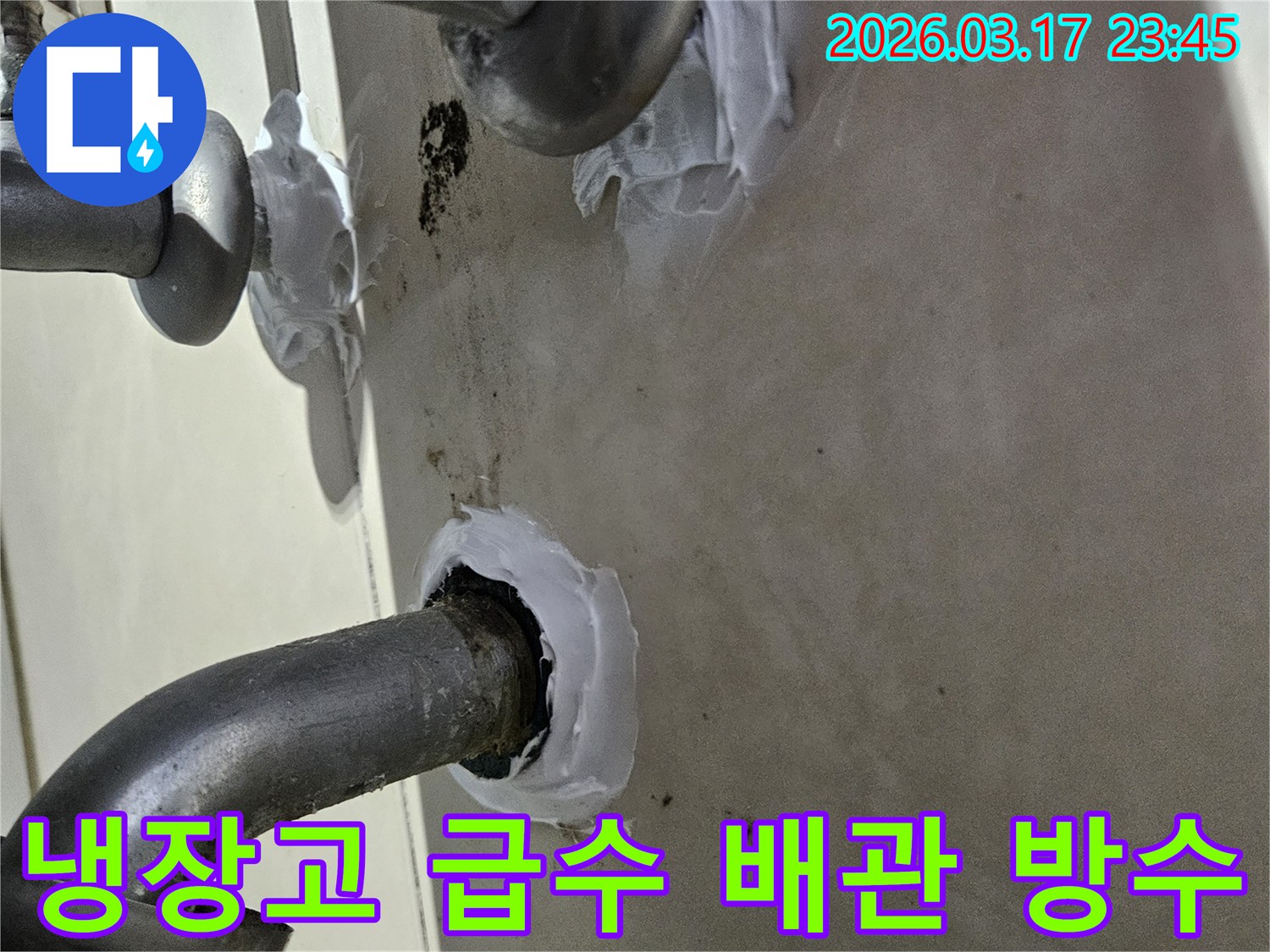오래된-음식점-주방-냉장고-급수-배관-틈새에서-발생한-누수를-방지하기-위해-실링-작업을-진행하는-모습