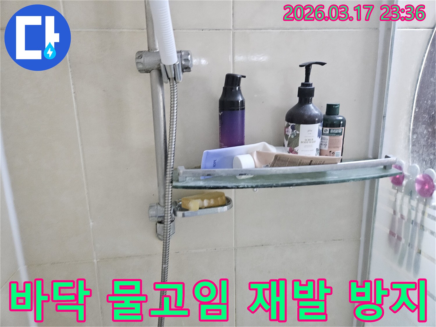 욕실 샤워기 옆-유리 선반에 맺힌 물방울은-바닥 물고임의 간접적인 증거를 보여주는 이미지입니다