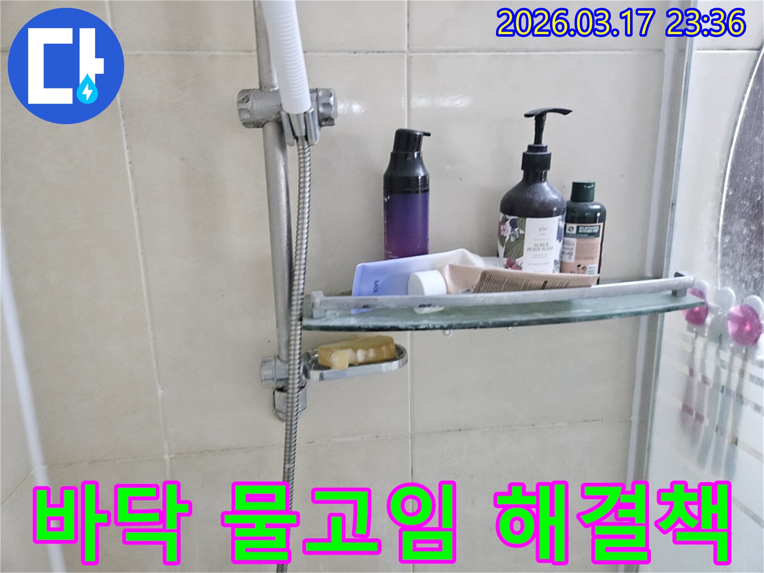 욕실 샤워기 옆-유리 선반에 맺힌 물방울은-바닥 물고임의 간접적인 증거를 보여주는 이미지입니다