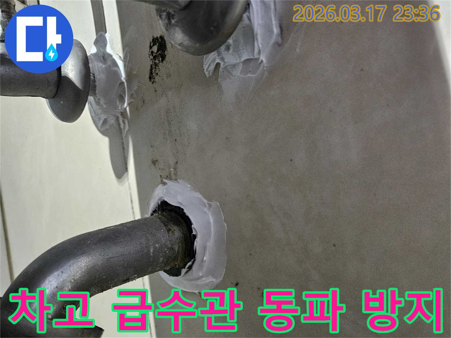 이 이미지는 병점동 주택 차고 급수관의 누수와 동파를 방지하기 위해-특수 방수 실란트로 꼼꼼하게 밀봉하는 과정을 보여줍니다-견고하고 오래가는 보수입니다.