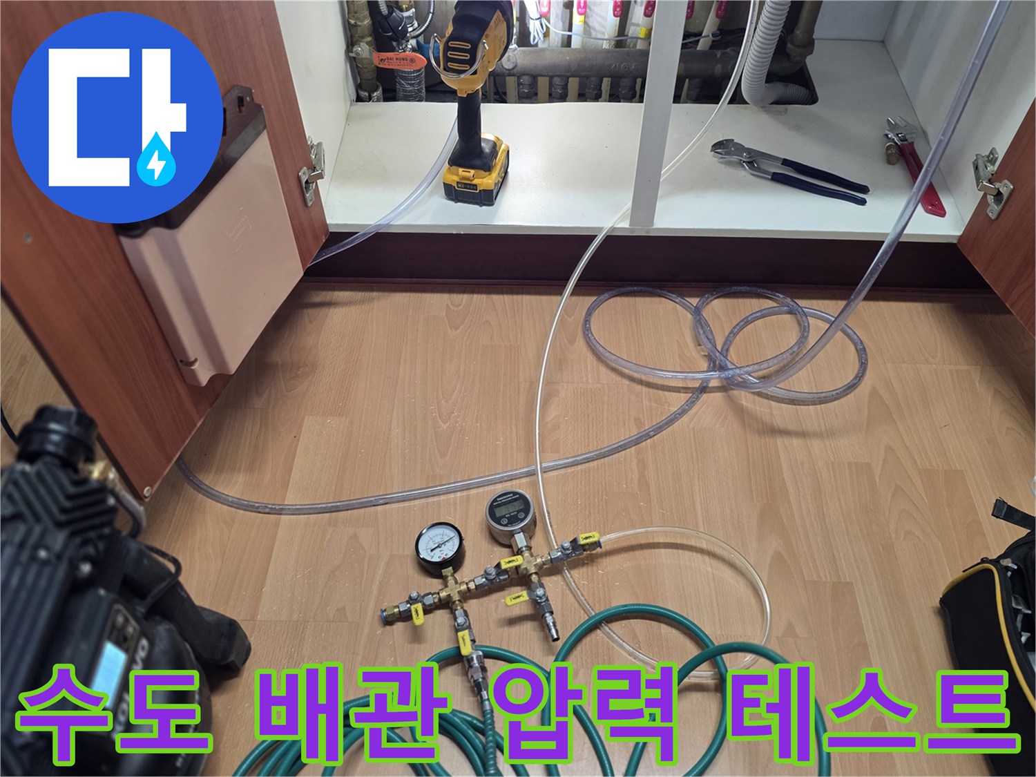 싱크대 하단 분배기에 연결된 공압 테스트 장비와 호스