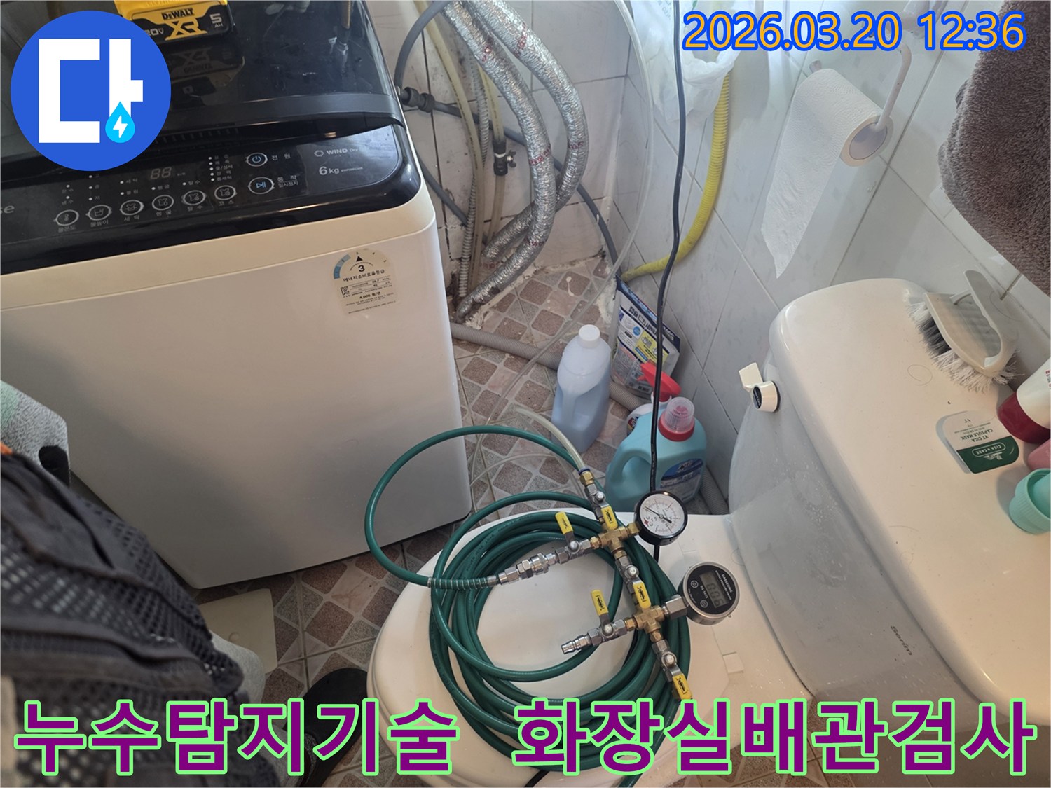 누수 엔지니어가 화장실 변기 위에 놓인-누수 탐지 장비를 통해-배관의 압력 변화를 면밀히 관찰하고 있습니다