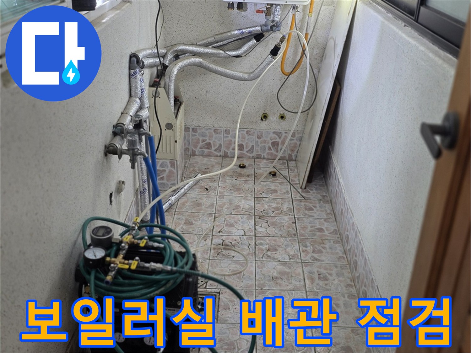 보일러실 벽면의 복잡한 배관들에 연결된 누수 진단용 호스