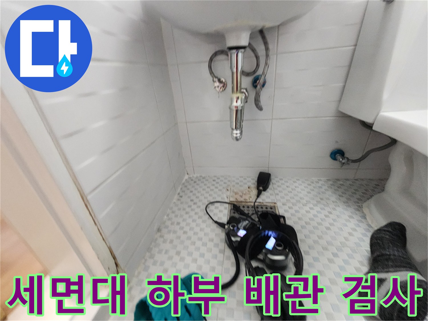 세면대 아래쪽 배관에 연결된 압력계와 청음용 헤드셋 사진입니다.