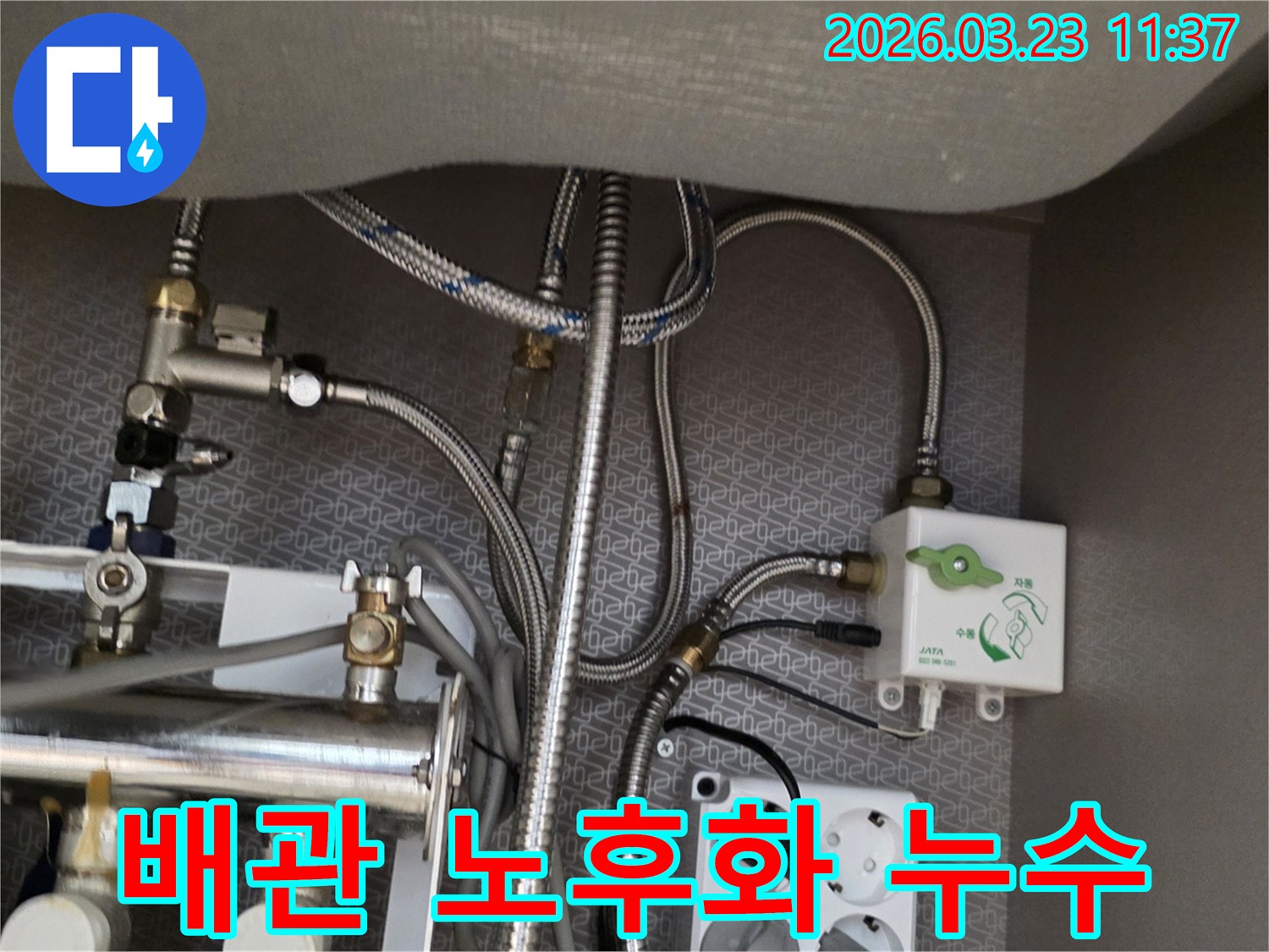싱크대 하부장 내부의 오래된 수도-배관과 정수기-연결-밸브-전기 콘센트가-보이는 곳에서-누수 흔적을-찾아내고 있습니다.