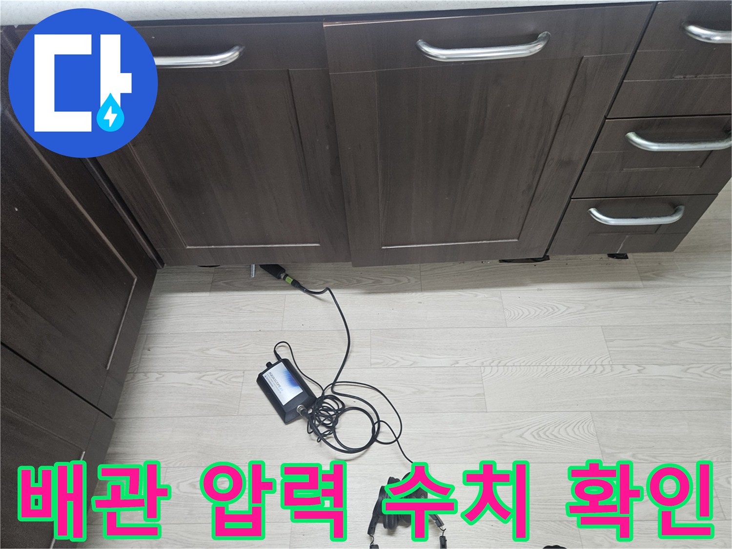 싱크대 밑 배관에 연결된 디지털 압력계와 연결된 호스들의 모습입니다.
