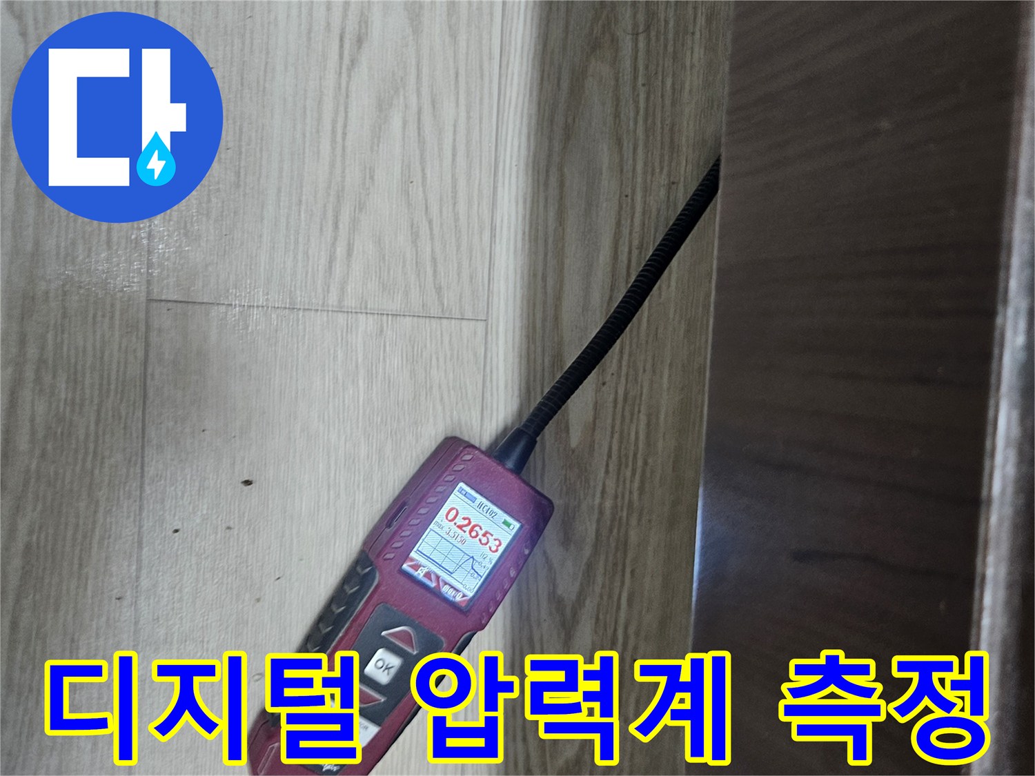 싱크대 하부 배관 점검을 위해 디지털 압력계를 연결하여 공압 테스트를 진행하는 모습입니다.