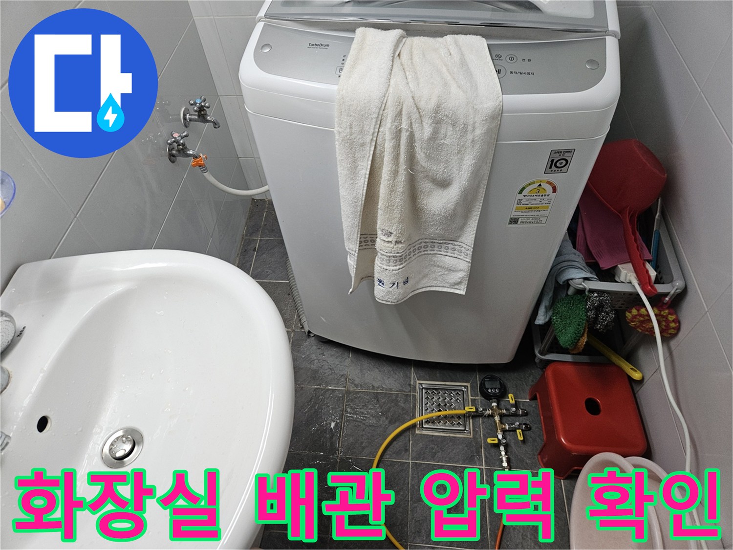 세탁기 옆 수전 부위의 디지털 압력계 설치 및 점검 장면