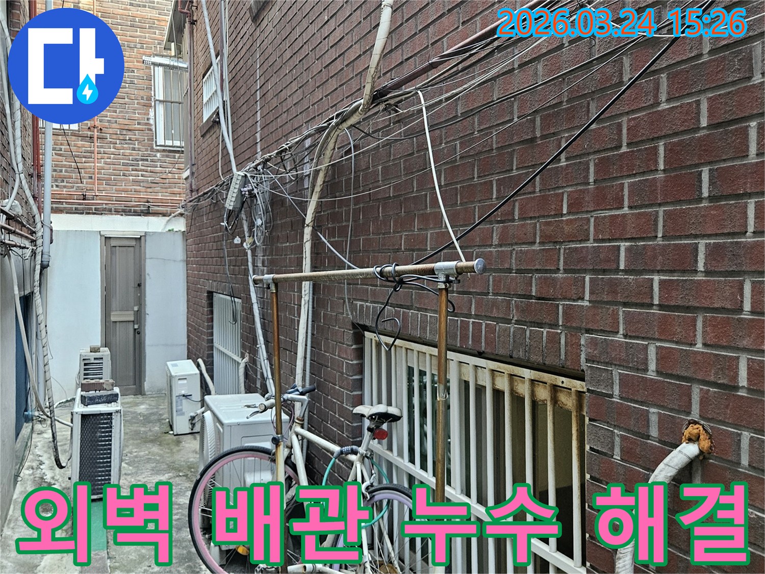 오래된 건물 외벽에-복잡하게 얽힌 배관과-전선-누수탐지 완료 후-현장 모습