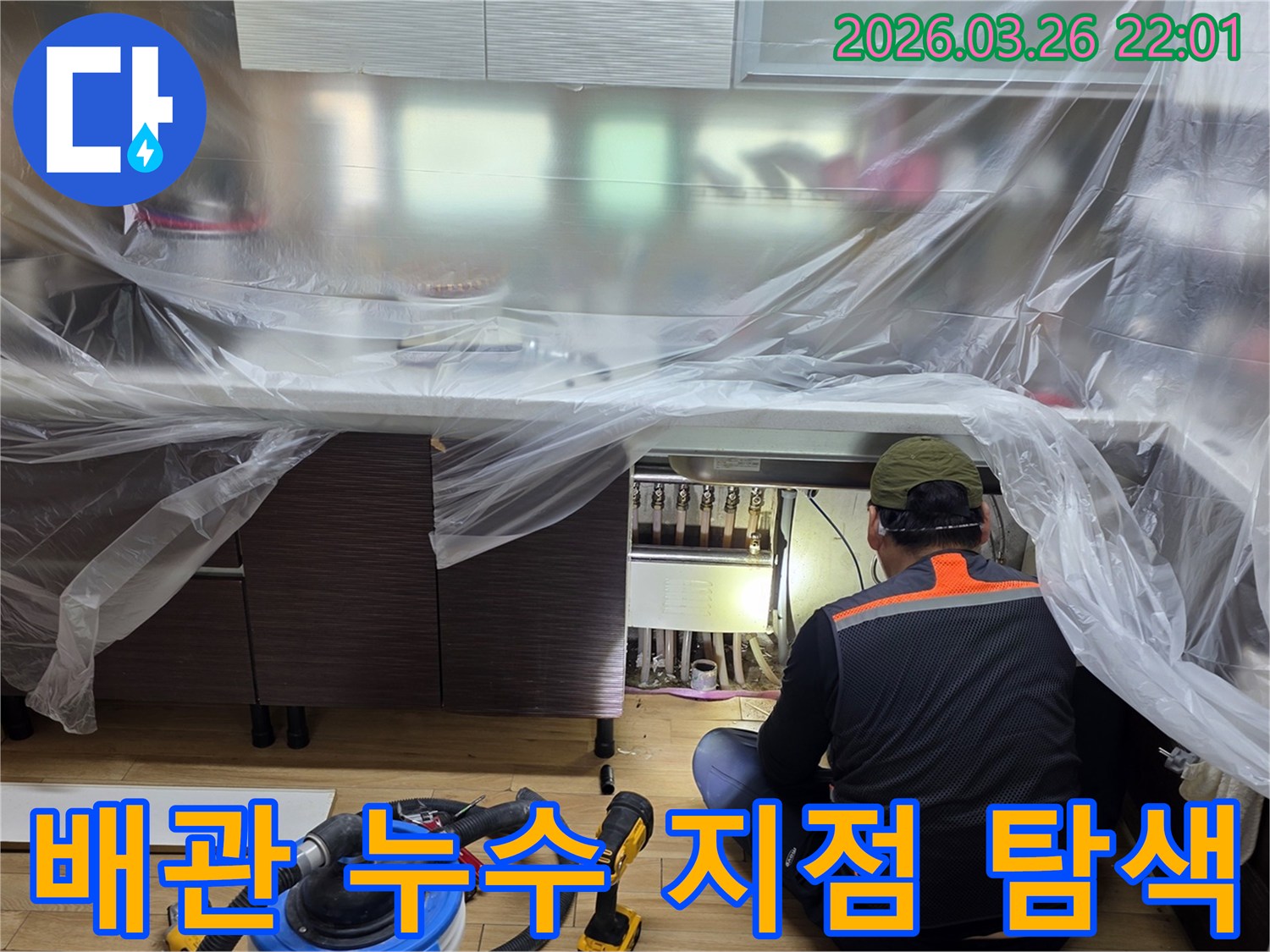 누수 엔지니어가-주방 하부장 아래-보일러 분배기 주변의-배관 연결부를-집중적으로-검사하고 있습니다.