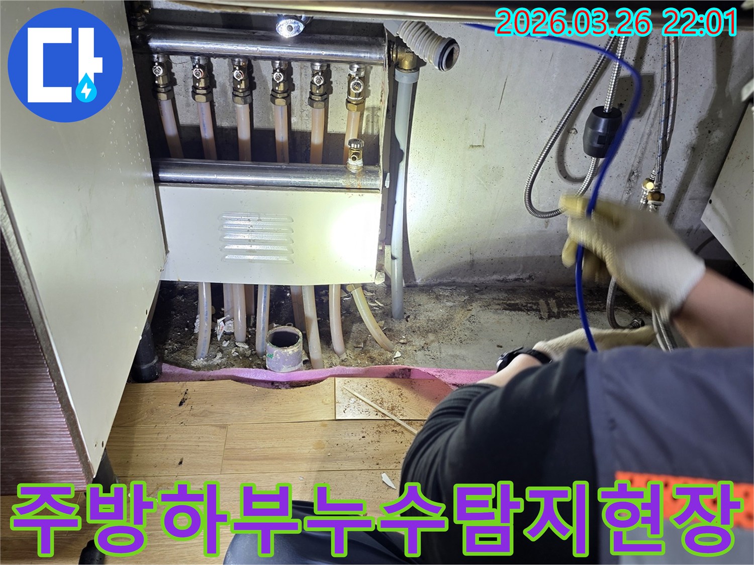 누수-전문가가-주방-싱크대-하부-배관에서-발생한-누수를-면밀히-조사하는-장면