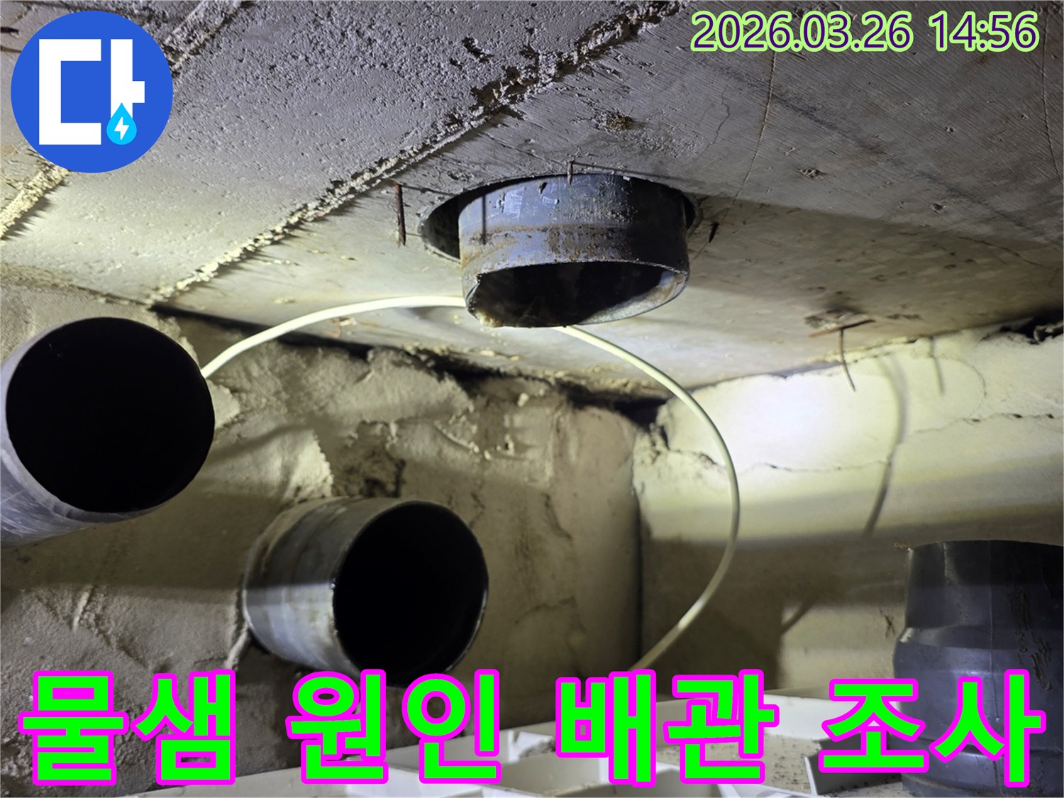 어두운 공간에서 조명을 비춰가며-배관의 이음새를 집중적으로 검사하는 모습