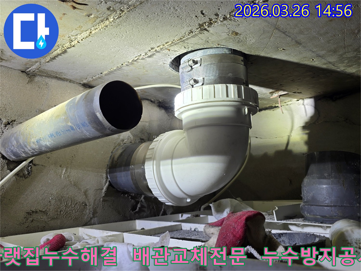 이 사진은 아랫집으로 이어지는 배관에서 발생한 누수를-새로운 배관으로 교체하여-재발을 방지하는-전문적인 공사 현장을 담고 있습니다.