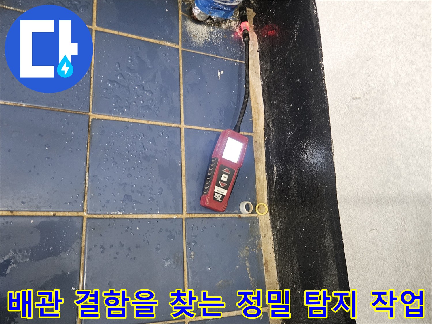 타일-바닥면의-누수-부위를-검사하기-위해-탐지기를-배치한-현장-사진