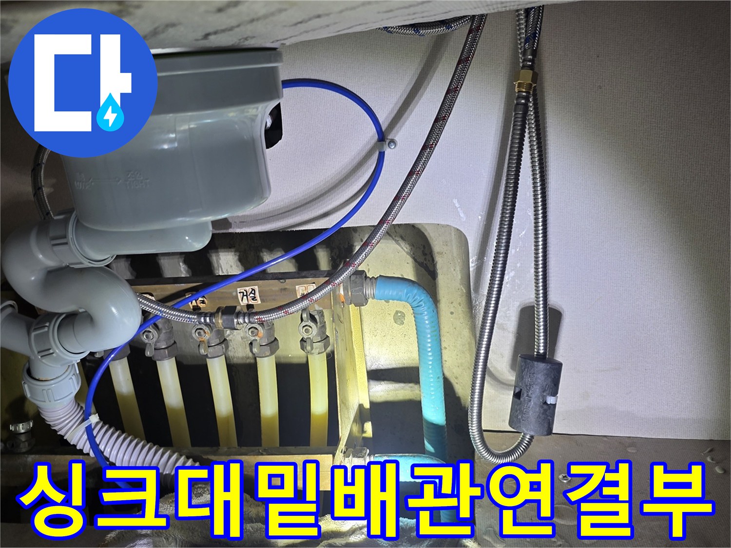 싱크대 하단 급수 밸브와 호스 연결 부위의 상세 모습