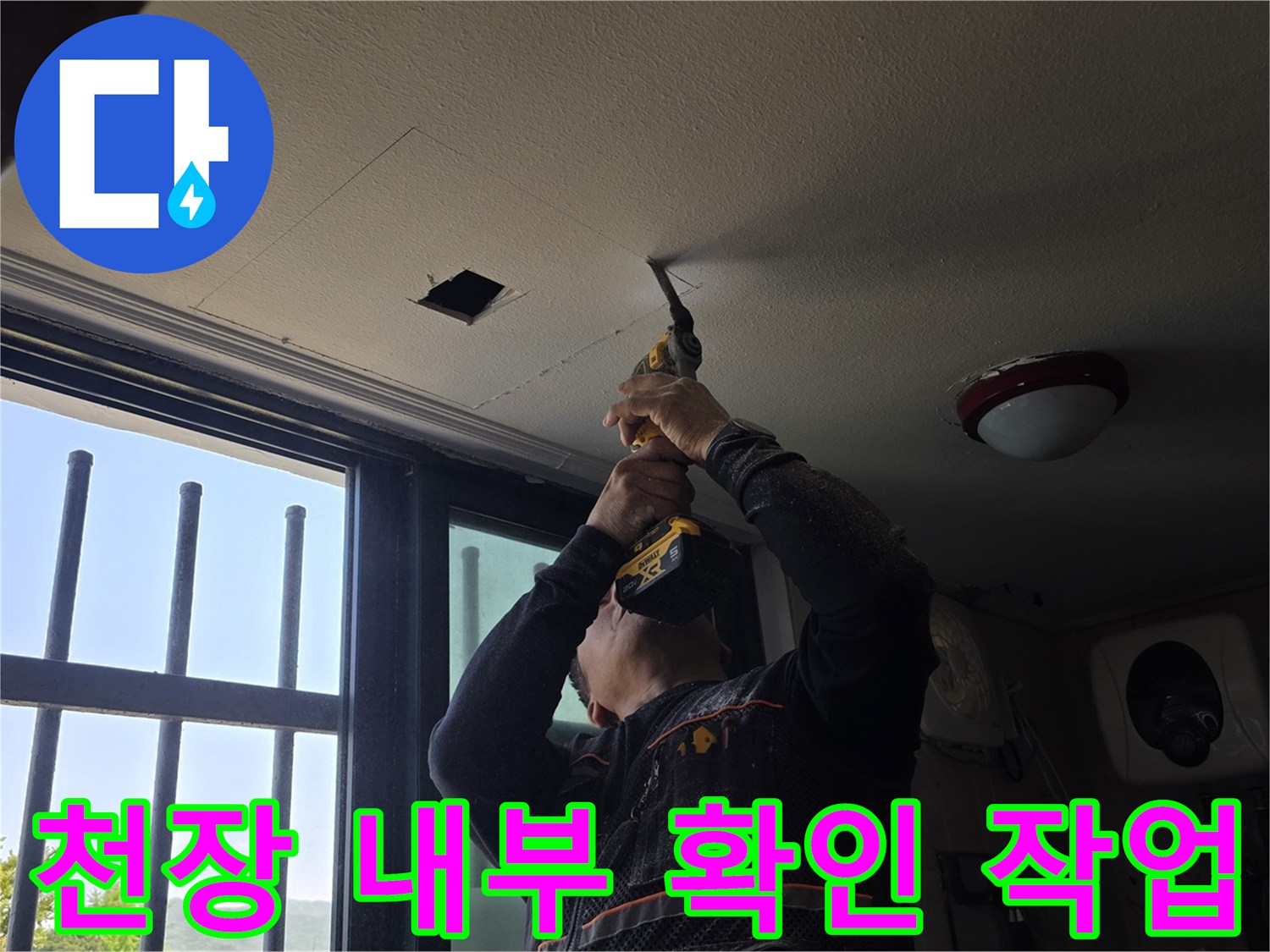 건물 천장 절개 - 드릴로 타공하여 배관 경로를 찾는 모습