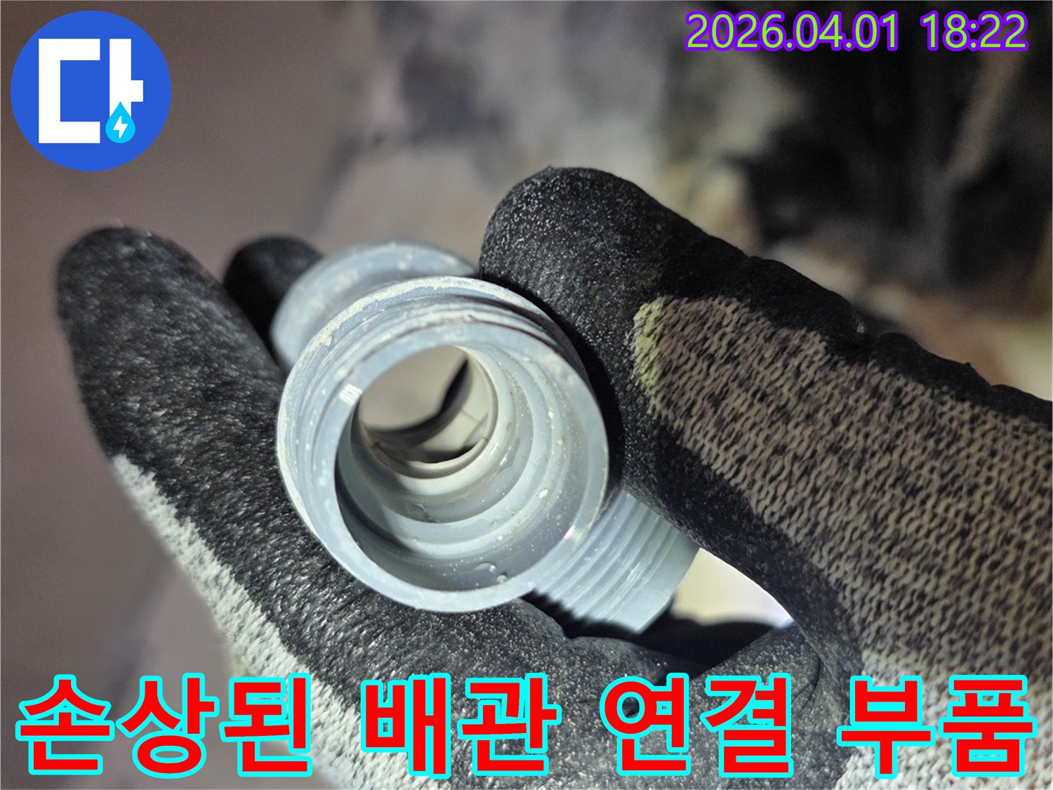 작업자가 손에 들고 있는-낡고 손상된 배관 연결 부품의 모습입니다.